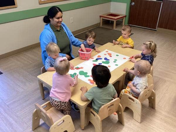 seven toddlers at a table, creating a college with their teacher