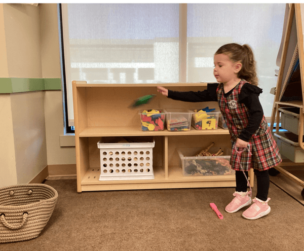 child throwing beanbag