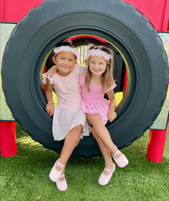 children sitting in a tire swing