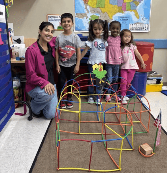 children posing in front of their building creation
