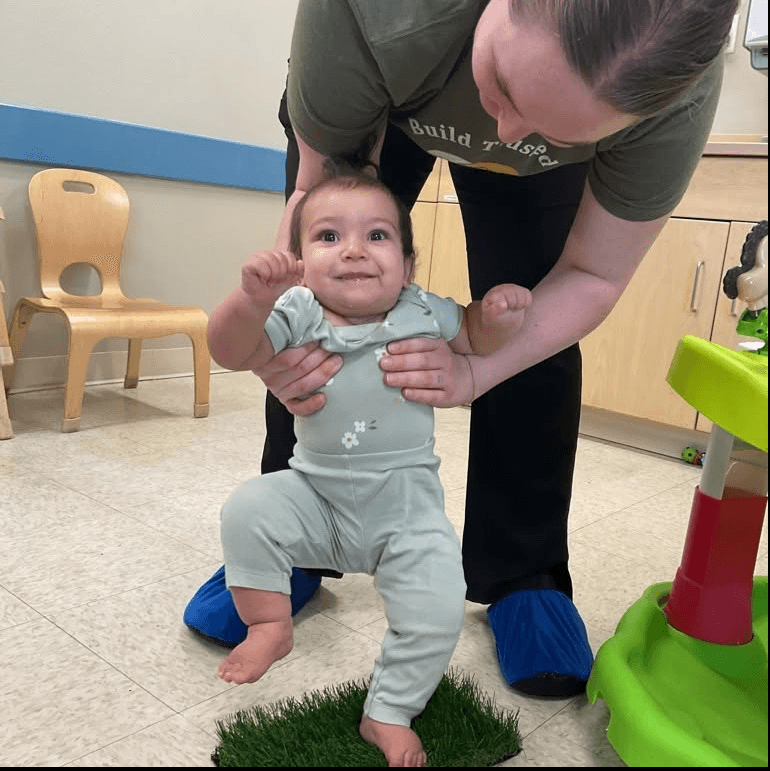 teacher helping baby walk