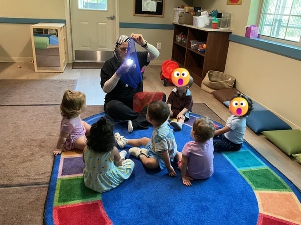 Toddler Classroom discovering how to color shadows using scarves