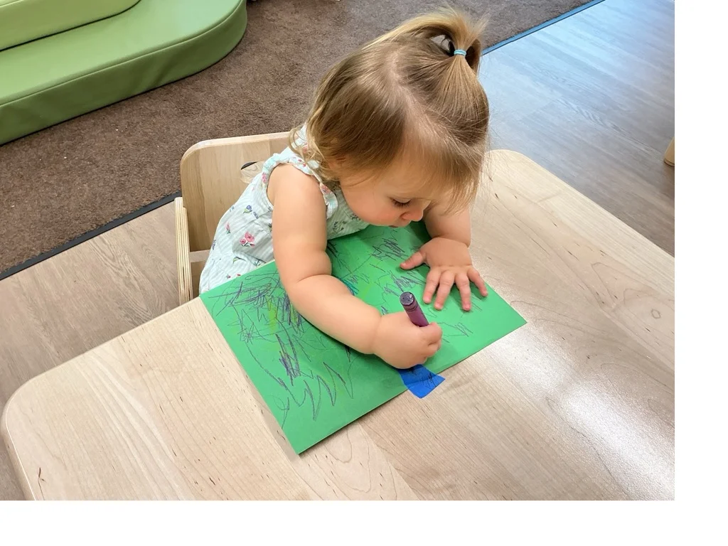 A child coloring with a crayon using an excellent pencil grasp.