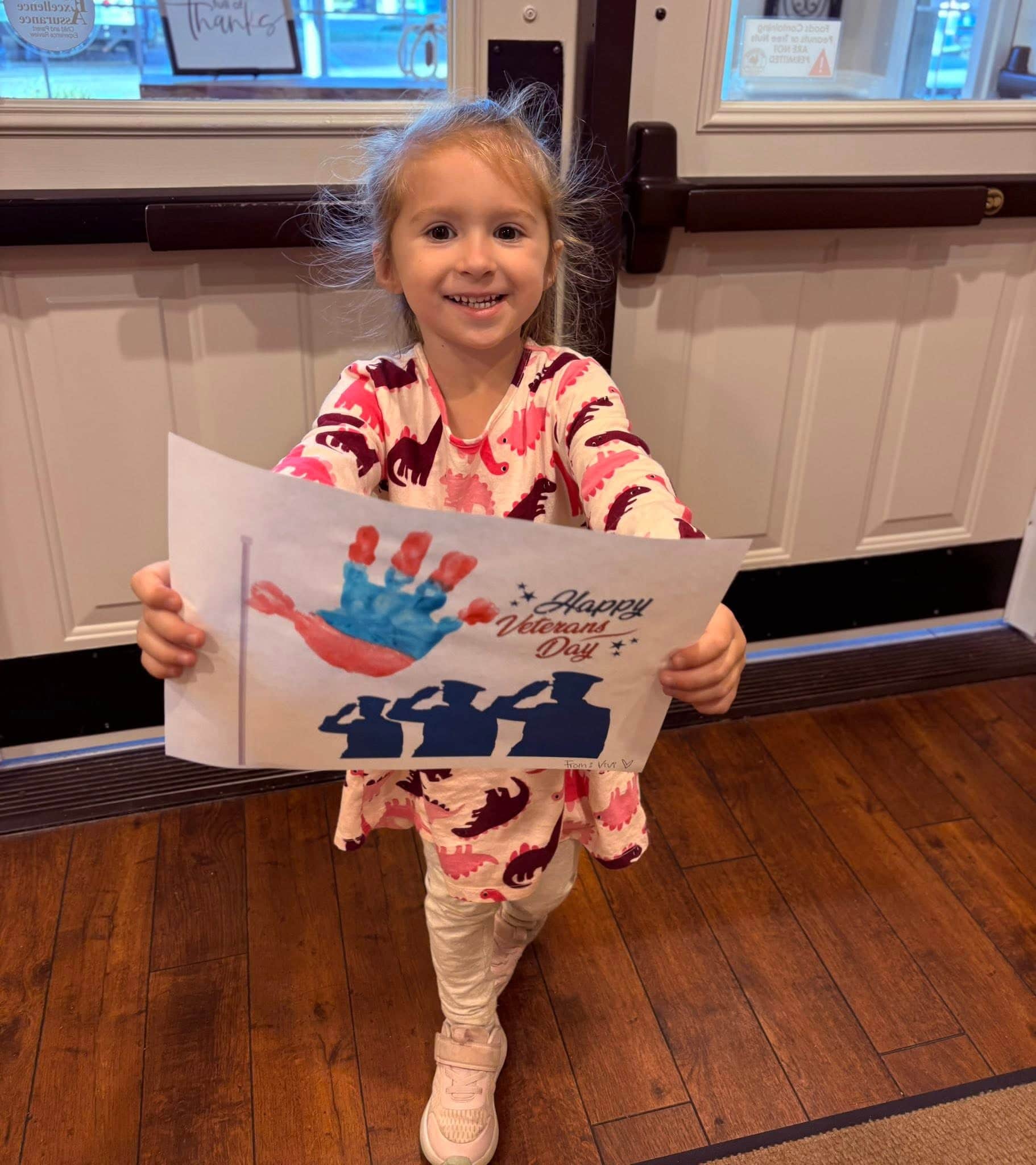 Child holding up a Veterans day craft