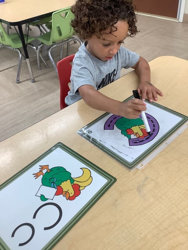 Preschool student tracing the letter C during an early literacy activity