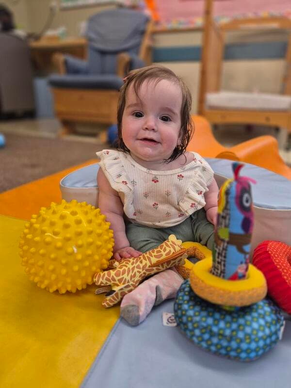 Infant participating in sensory play activities at Primrose School, supporting physical development, exploration, and confidence-building.
