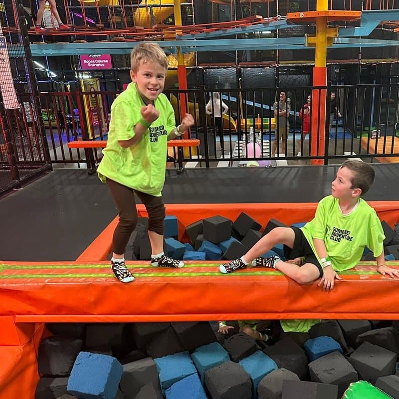 Children enjoying active play and physical challenges at an indoor adventure park during a school-age program activity in Highlands Ranch, CO.
