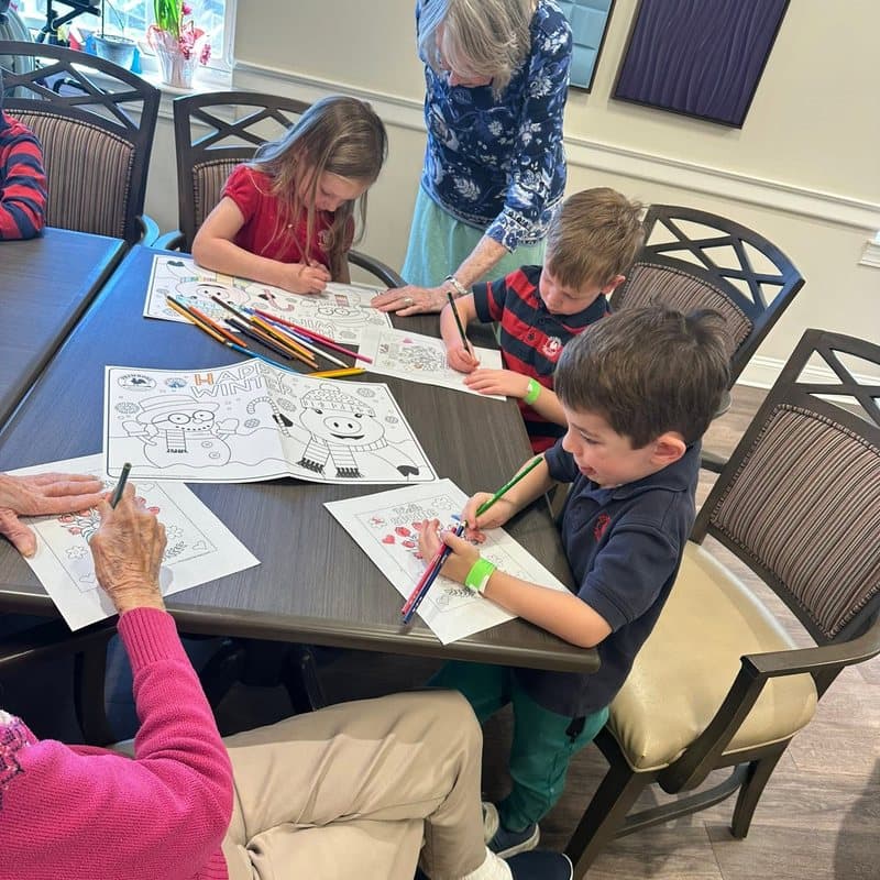 Children participating in a creative coloring activity with older adults during a Before and After School community activity in Highlands Ranch, CO.