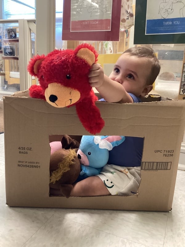 Baby in a box holding a puppet