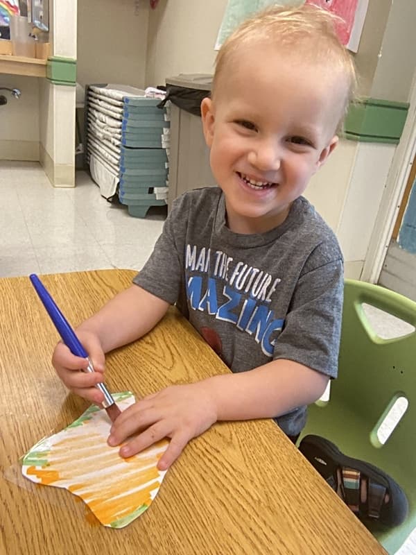 Boy painting a dirty tooth with white paint