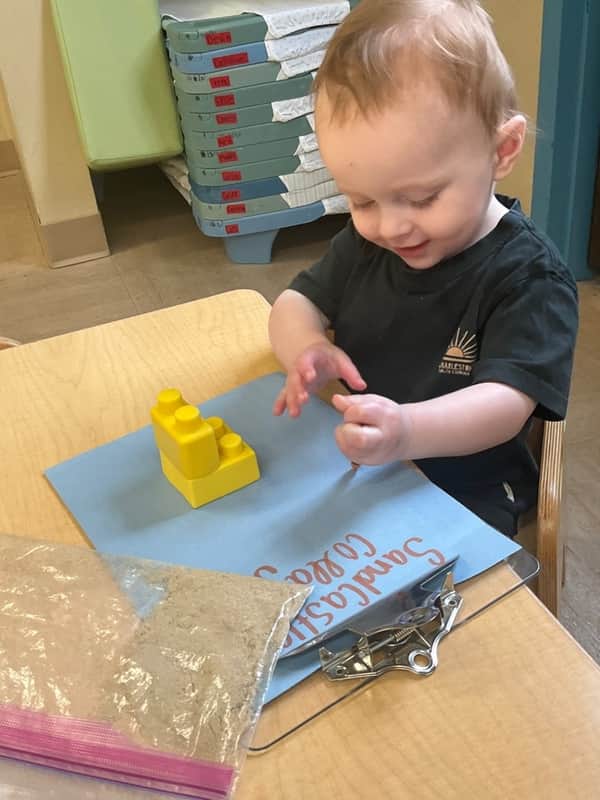 child exploring sand