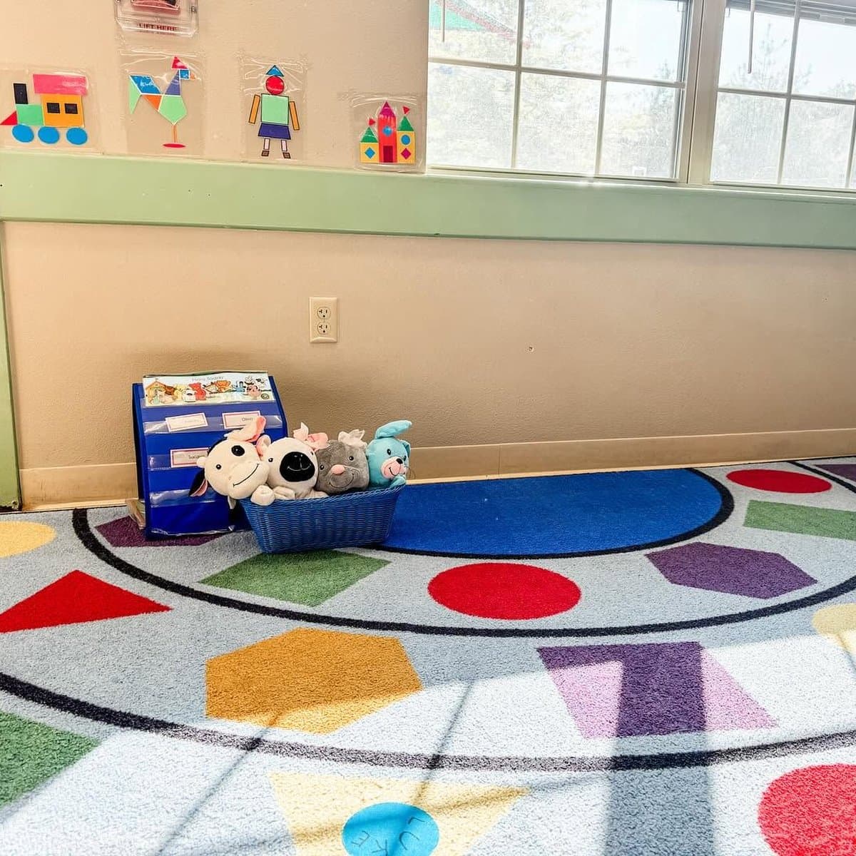 Colorful shapes rug and stuffed animal reading corner in early preschool classroom at Primrose School of Chelmsford, MA
