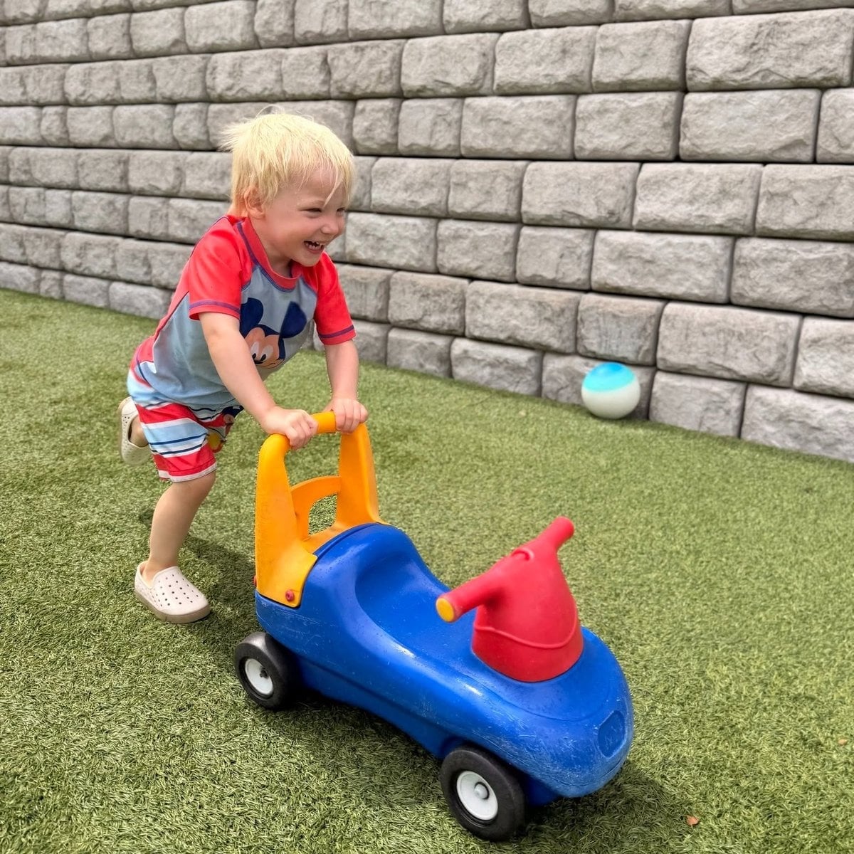 Early preschool children playing at outdoor water sensory table at Primrose School of Woburn, MA