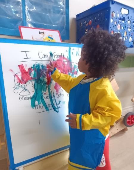 two year old paints in a classroom