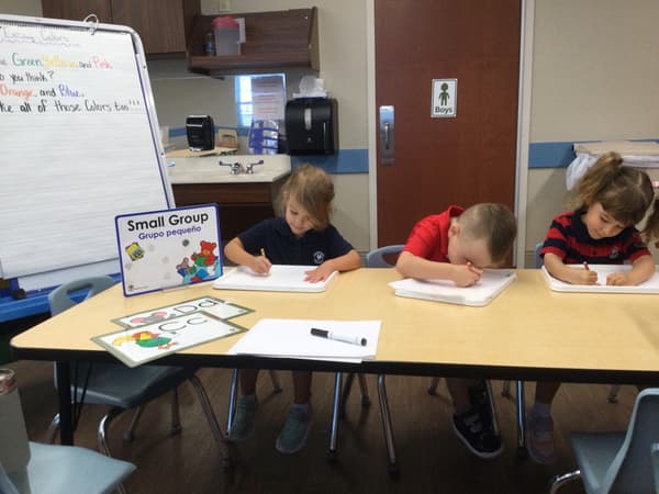 Pre-K children completing a teacher guided literacy lesson reviewing letters and rhyming words
