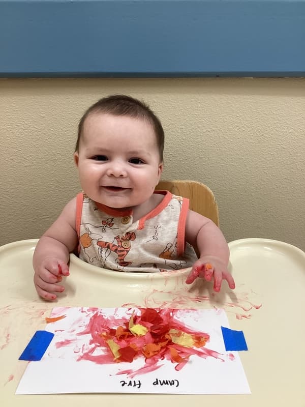 An infant child painting and making art at primrose school, the best early education in fort worth, saginaw, texas