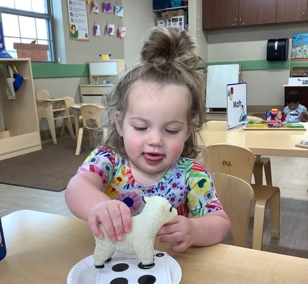 Enrolled toddlers doing hands-on activities with teacher guidance