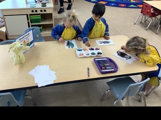 Children sitting at a table painting