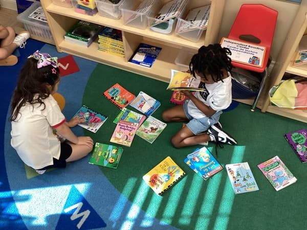 children sitting on the floor with books all around them