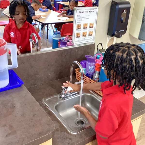 student washing their hands