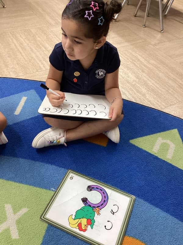 Pre-K student practices handwriting during small group literacy