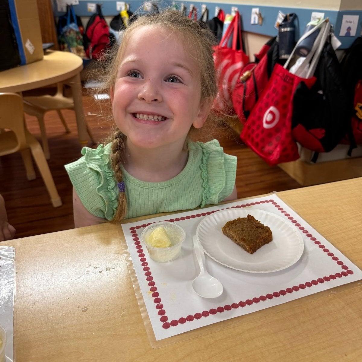 Pre-K girl smiling with her homemade baked treat during a cooking project at Primrose School of Chelmsford in Chelmsford, MA