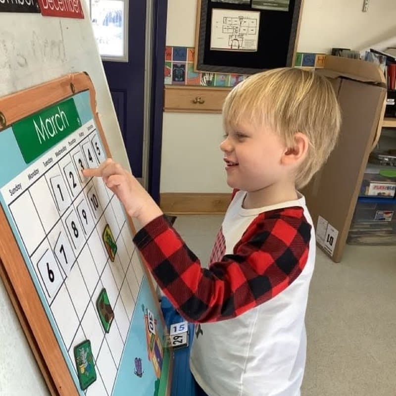 Preschool child practicing calendar and number recognition at Primrose School at Highlands Ranch Business Park in Highlands Ranch, CO.