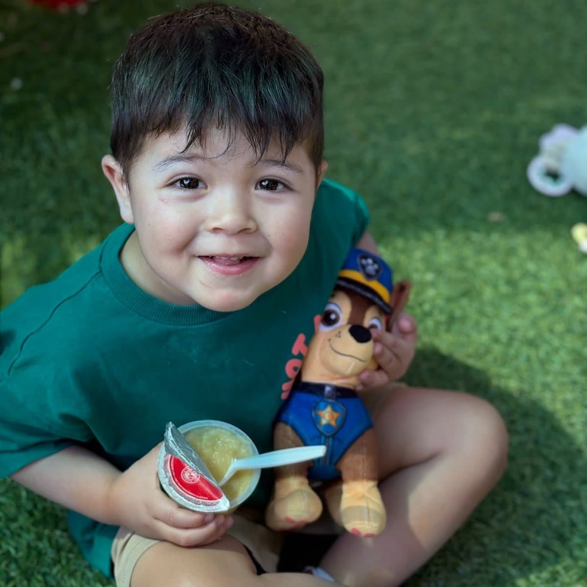 Smiling preschool boy enjoying outdoor snack time at Primrose School of Chelmsford preschool program in Chelmsford, MA