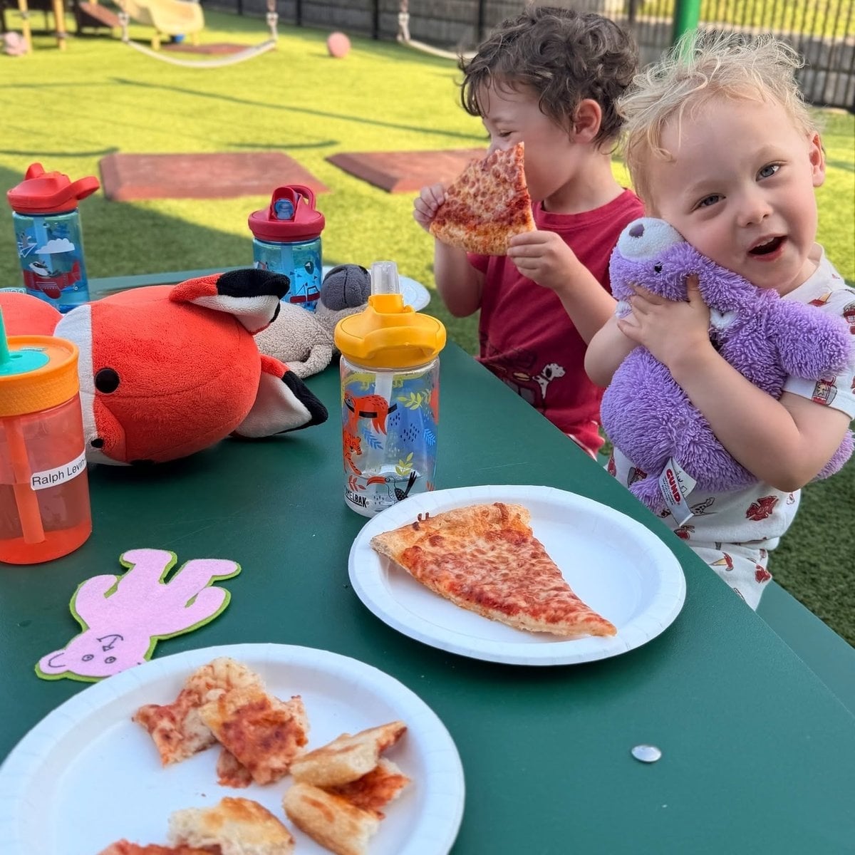 Preschool children enjoying an outdoor pizza lunch on the playground at Primrose School of Woburn, MA