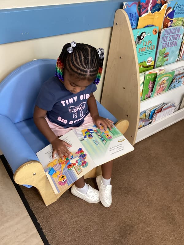 Preschool child reading a book at Primrose School at Summerwood