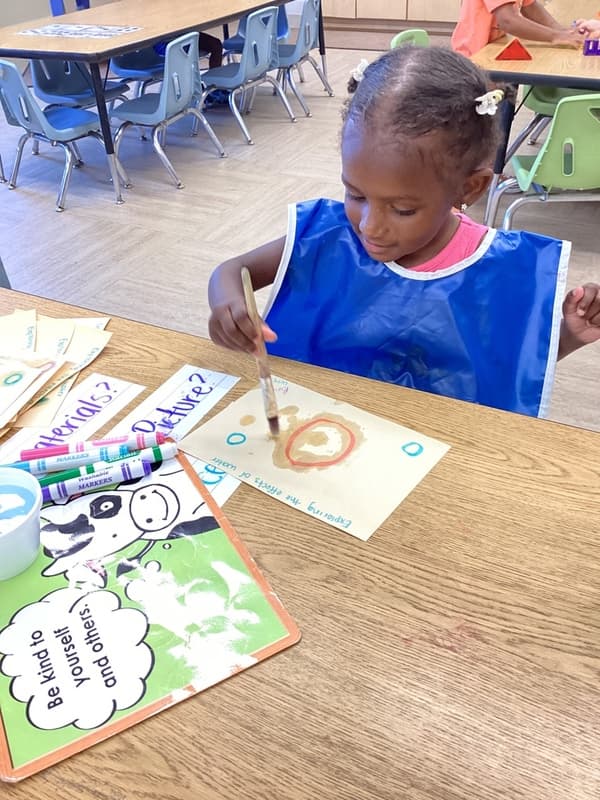 child water colors with a smock on