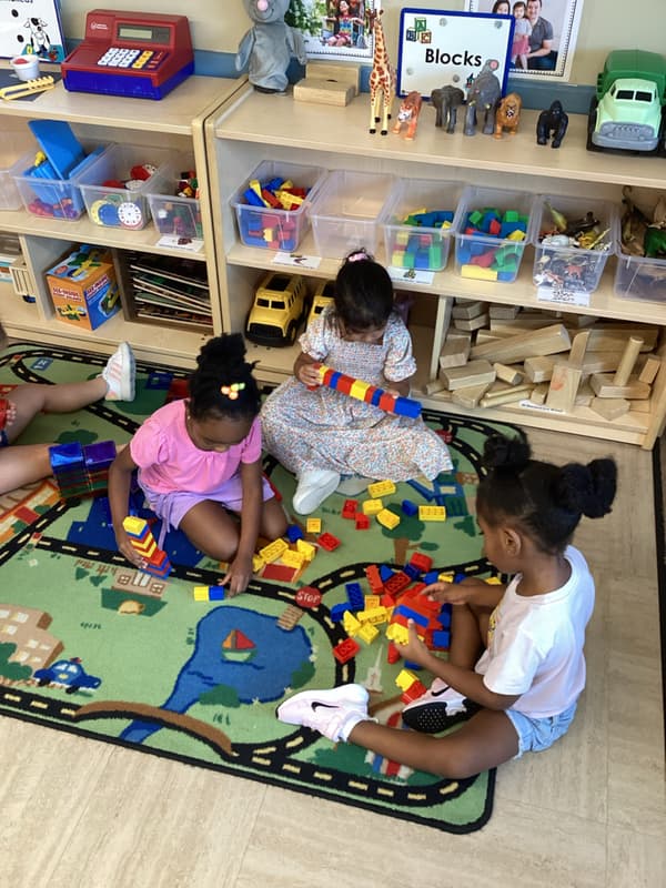 three children build with blocks