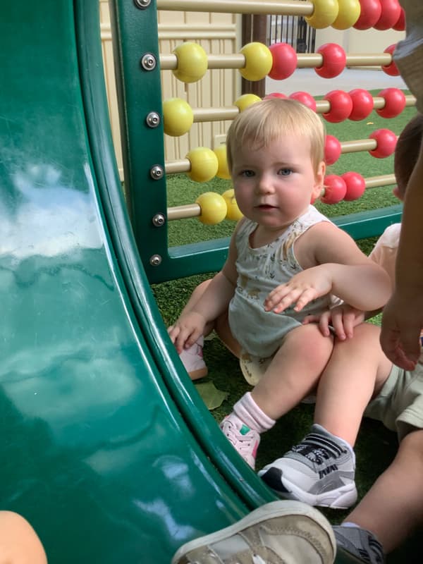 toddler on the playground near a tunnle