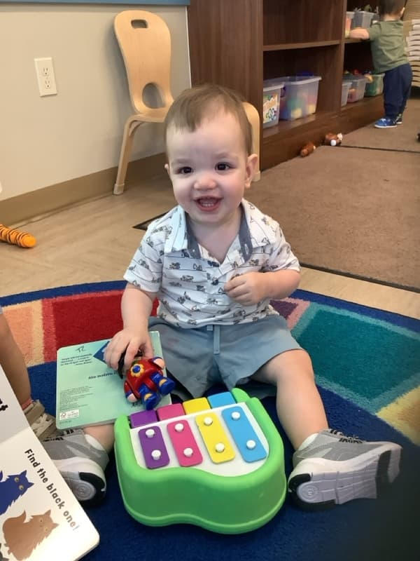toddler playing an instrument in the classroom