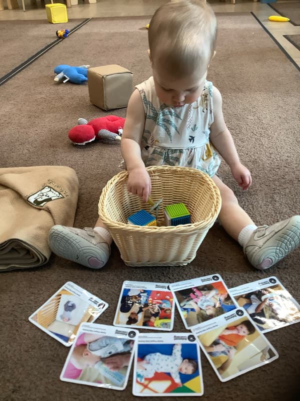 child explores manipulatives in a basket during circle time