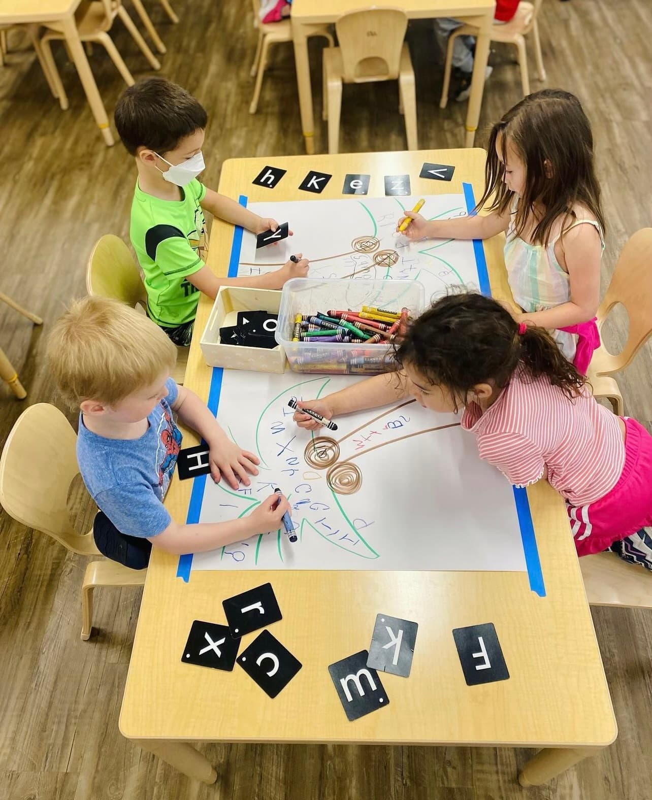 Preschool students working on activity with letters