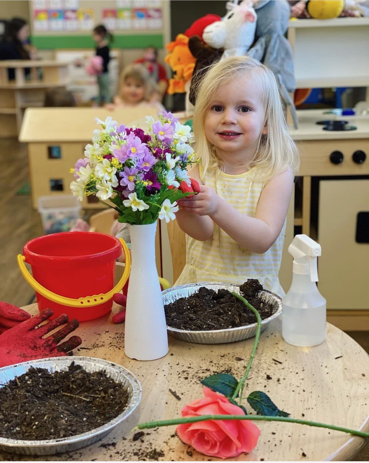 Preschool student planting flowers