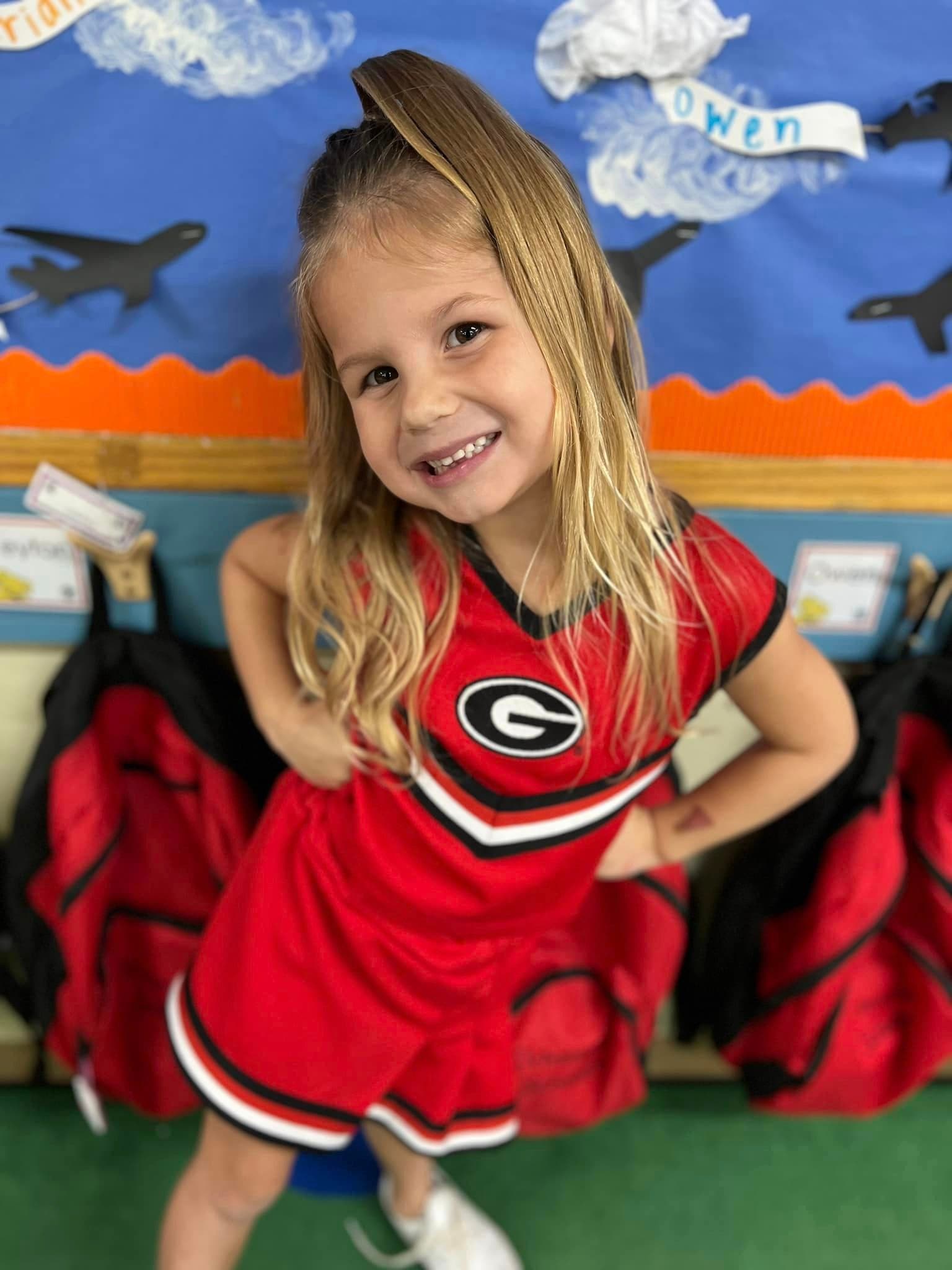 child dressed in university of georgia cheerleader outfit