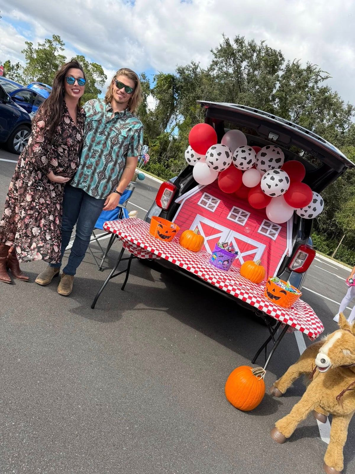 two adults in front of a farm theme decorated trunk