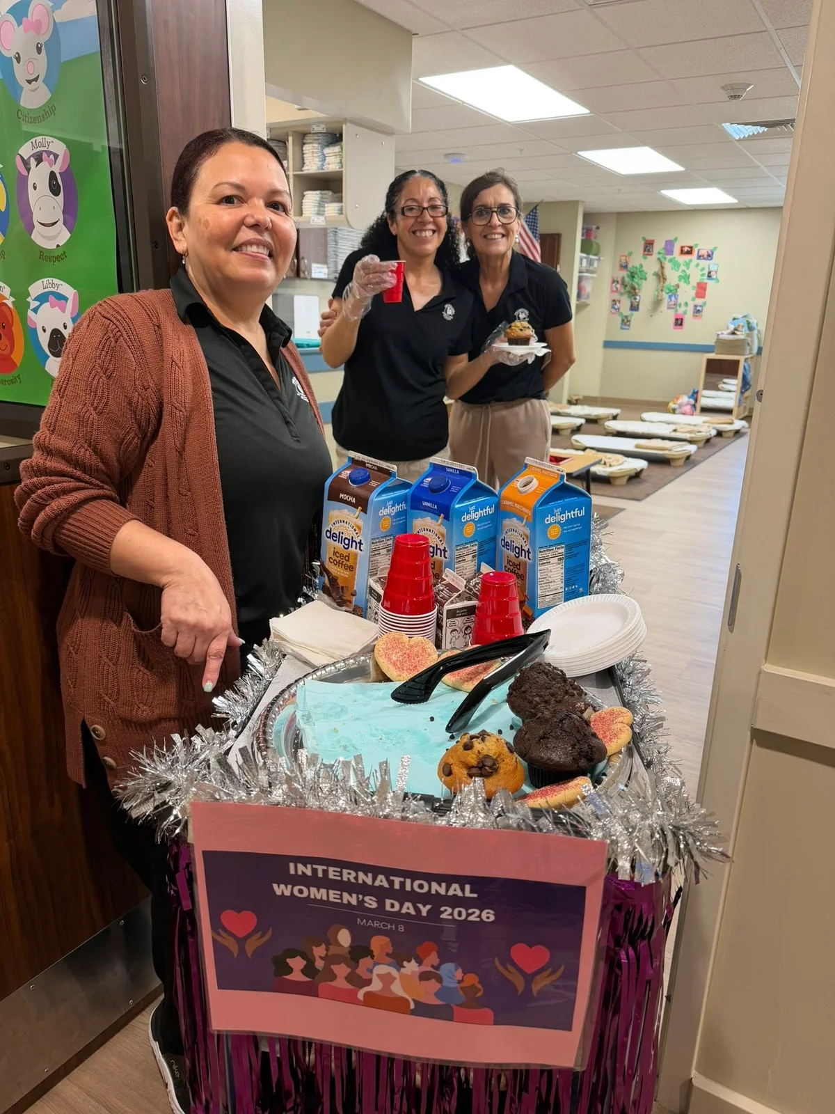 three women with coffee muffins and cart
