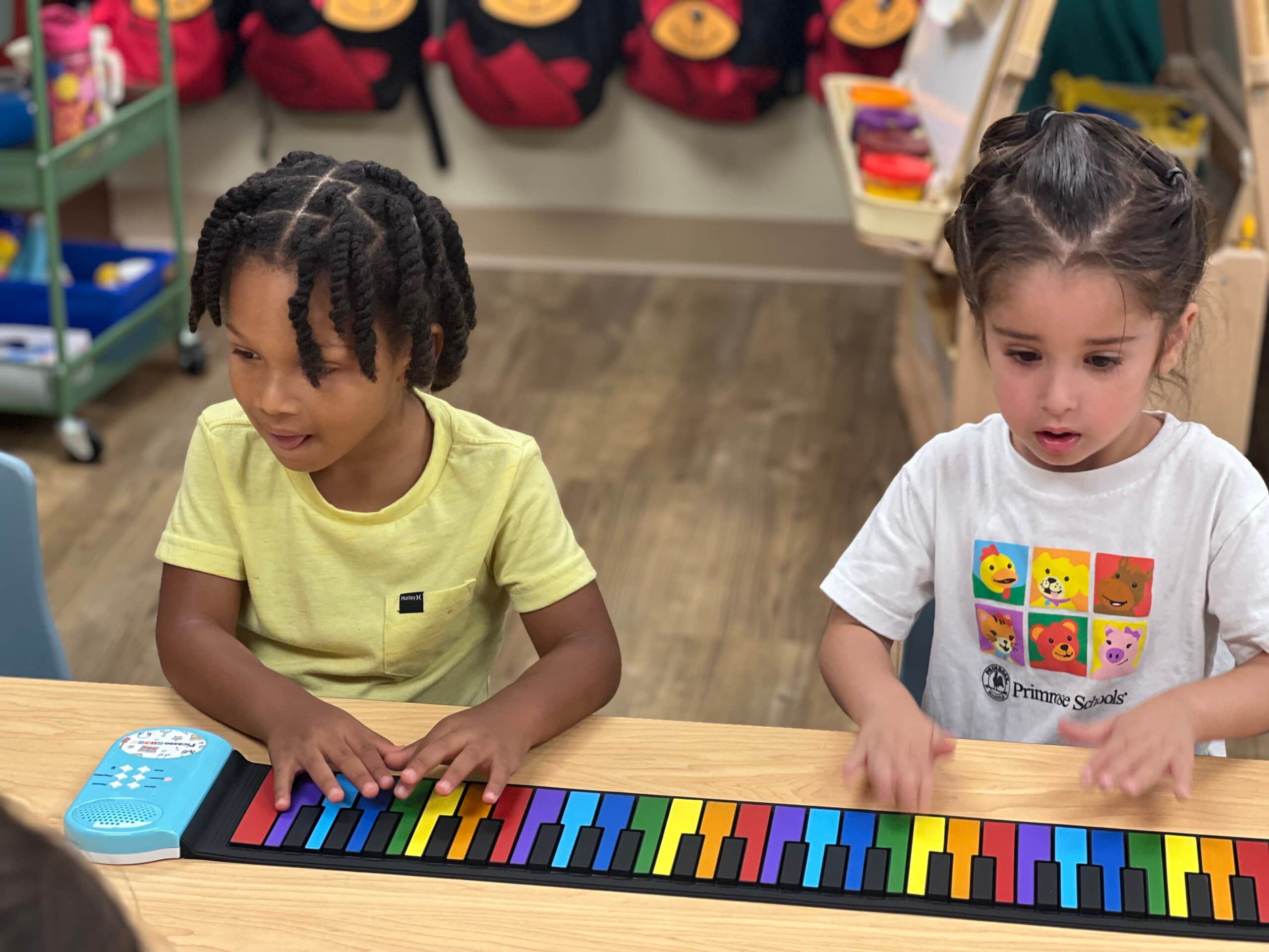 Preschool student pressing keys on a digital piano during a music and piano enrichment class at Primrose School of Novi.