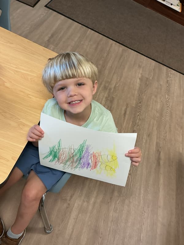 Preschool student drawing and creating artwork in a Primrose classroom during a hands-on learning activity
