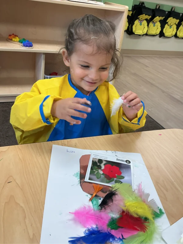 Young girl drawing and creating art in a Primrose preschool classroom during a creative learning activity