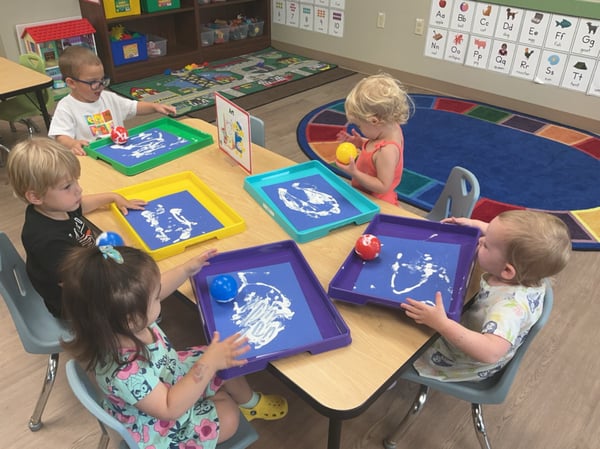 Early Preschool children explore art, color and movement through a hands-on Art Masters painting activity at Primrose School of Forest Hill.