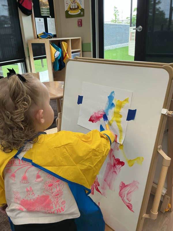 Primrose School of Clintonville Toddler student painting and exploring