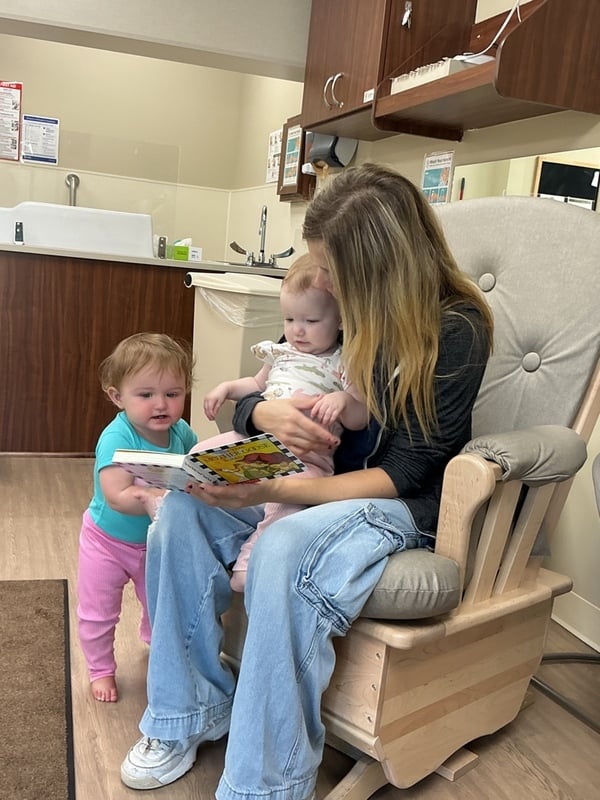 Primrose School of Clintonville Infant Teacher Reading A Book