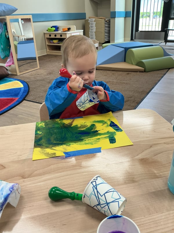 Primrose School of Clintonville Toddler student painting and exploring