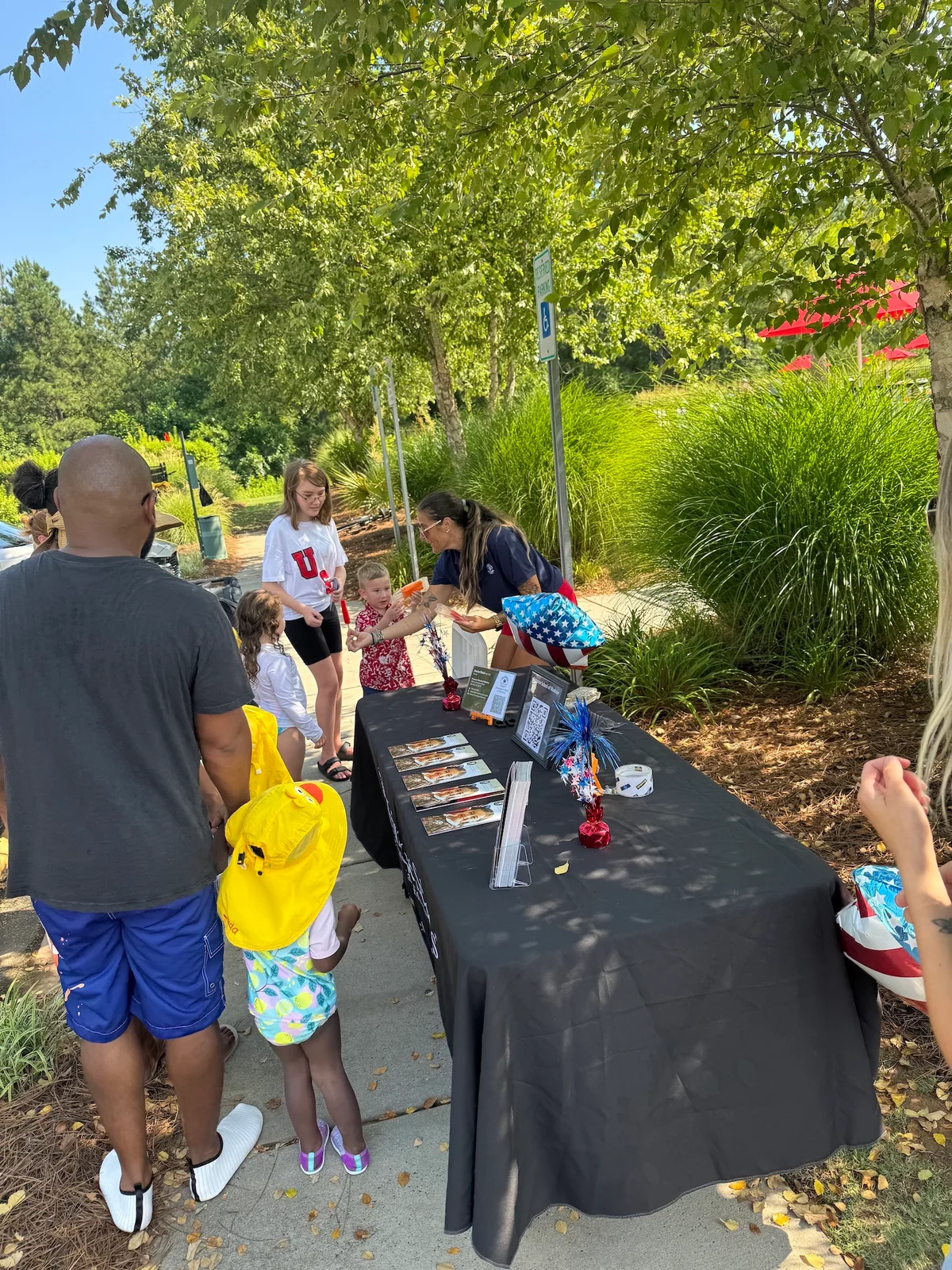 image shows families talking with Primrose waxhaw staff and enjoying popsicles
