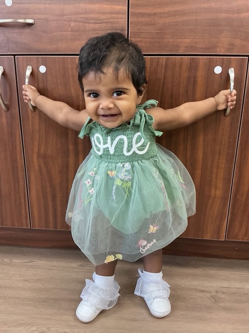 Smiling young toddler celebrating a first birthday milestone while building confidence and independence in the nurturing environment at Primrose School.