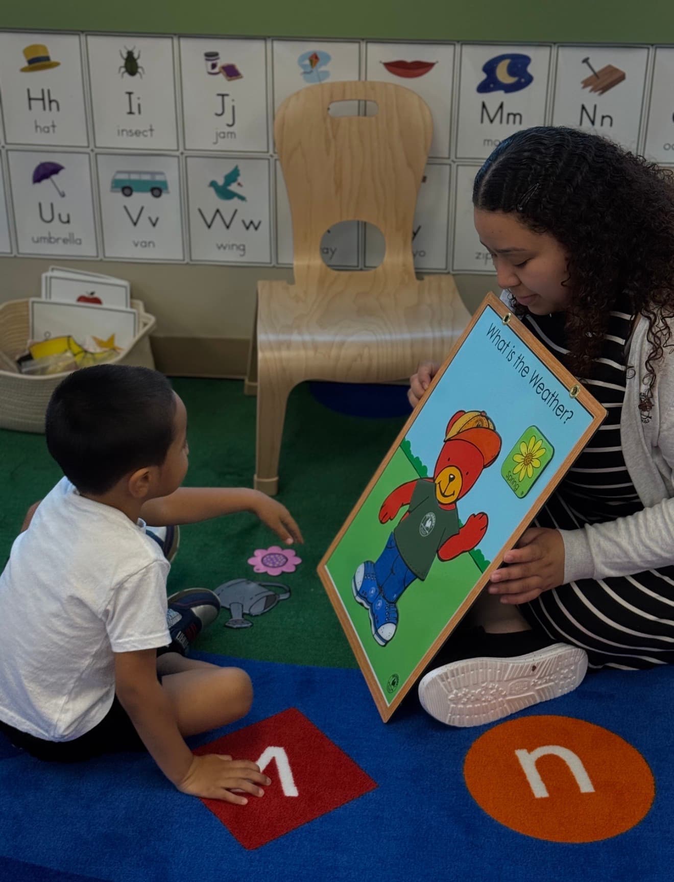 teacher and child dressing weather bear